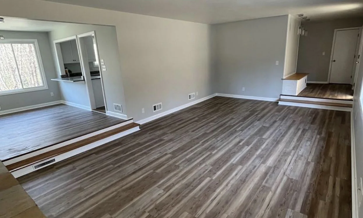 Living room with step-down and new vinyl plank flooring by Tauro Builders