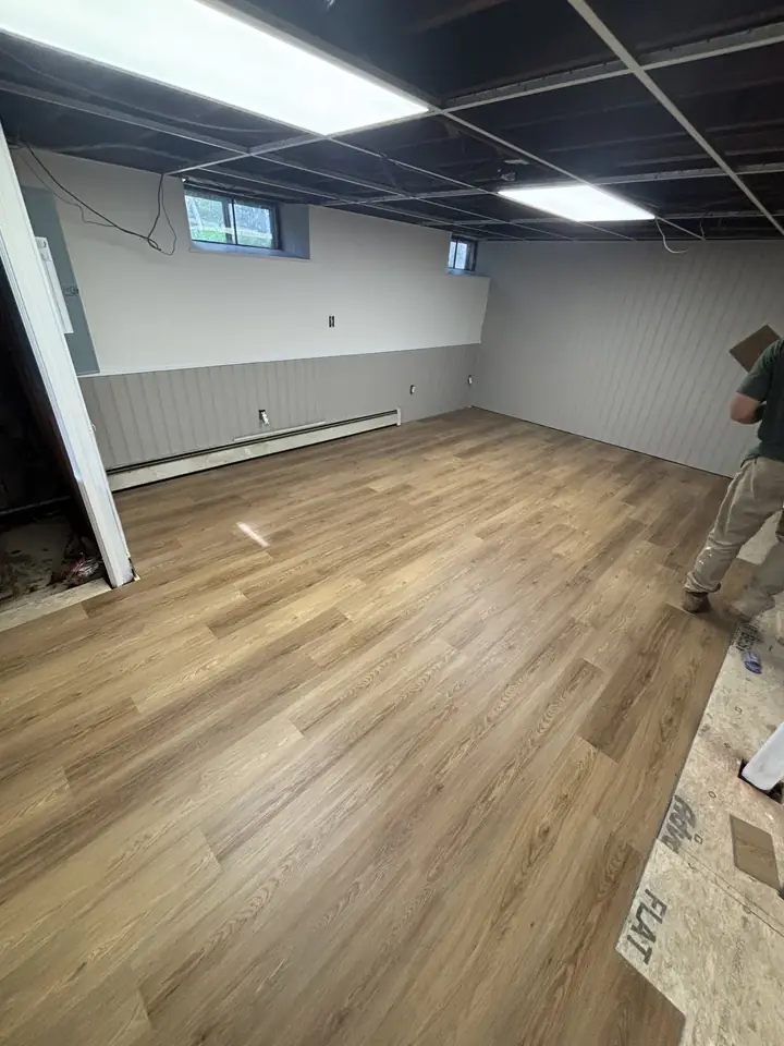 Finished basement with new flooring by Tauro Builders
