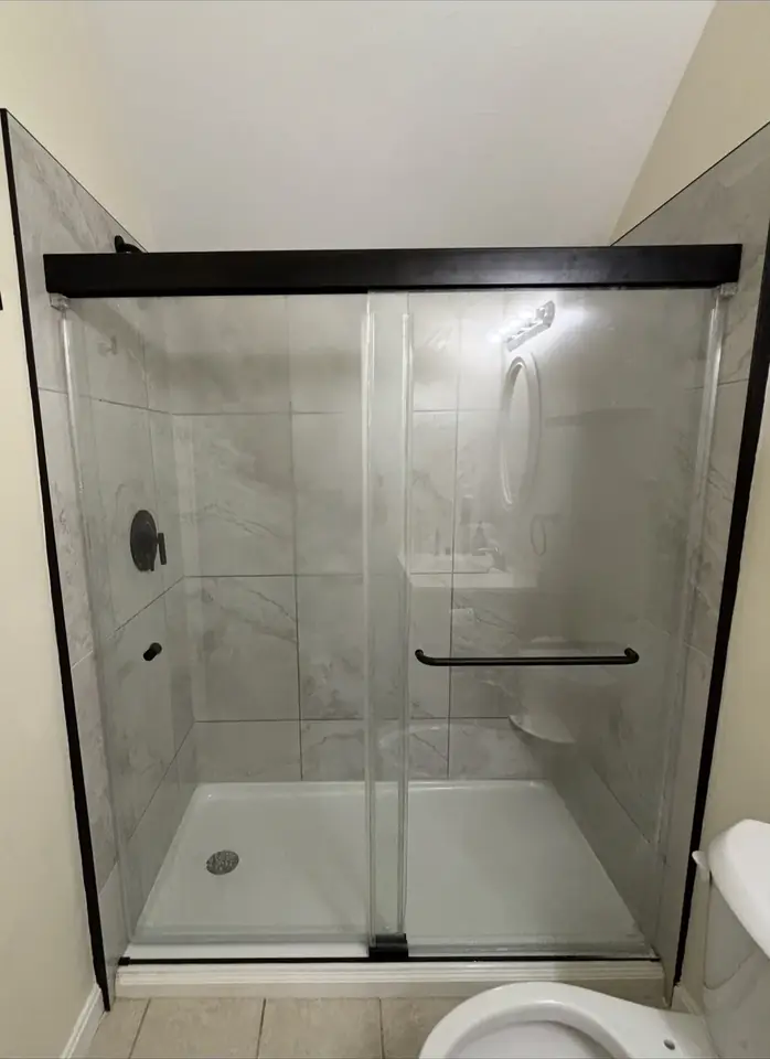 Tiled shower with glass enclosure by Tauro Builders