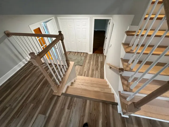 Open staircase with oak treads and railing by Tauro Builders