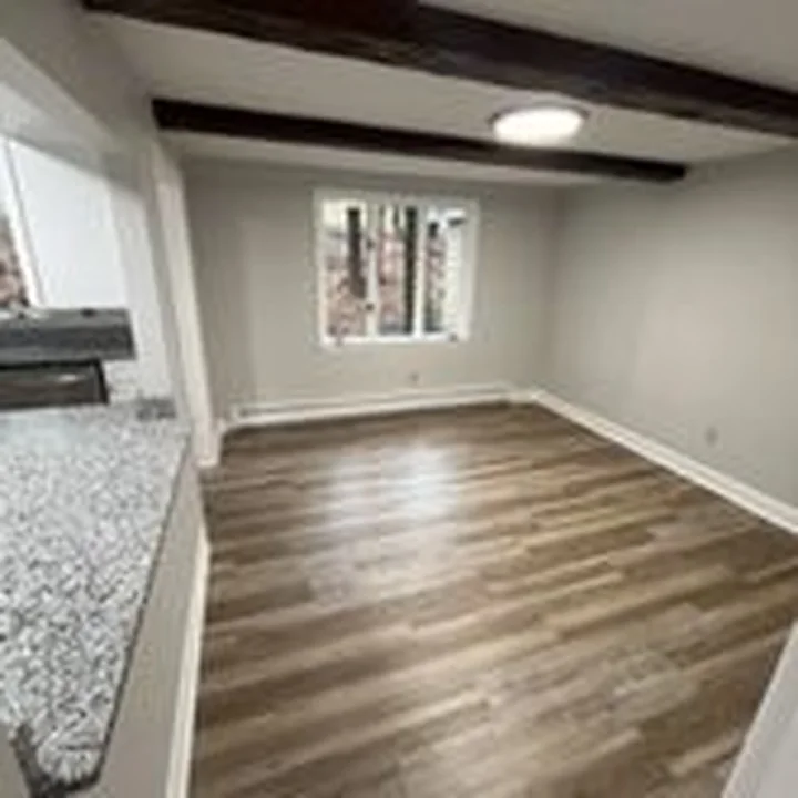 Beamed room with new vinyl plank flooring by Tauro Builders